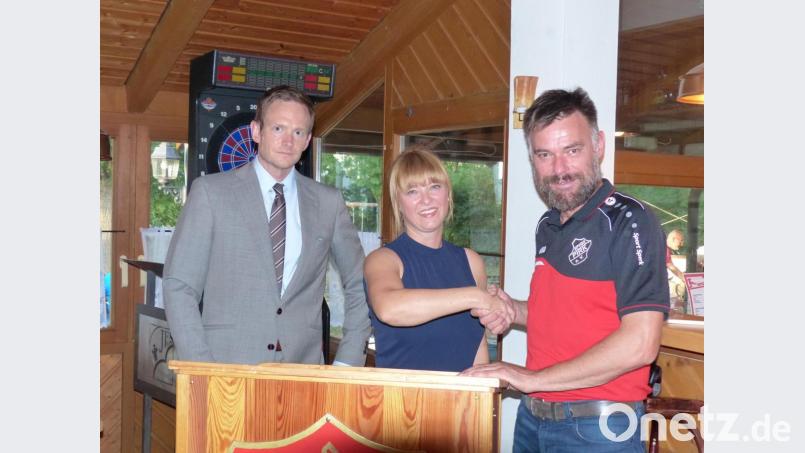 Mit Handschlag besiegeln die beiden Vorsitzenden, Melanie Neiser (Mitte) vom SKK Pirk und Josef Schiesl (rechts) von der SpVgg die Fusion die Fusion, die Notar Thomas Schiffner rechtlich begleitet. Bild: hme