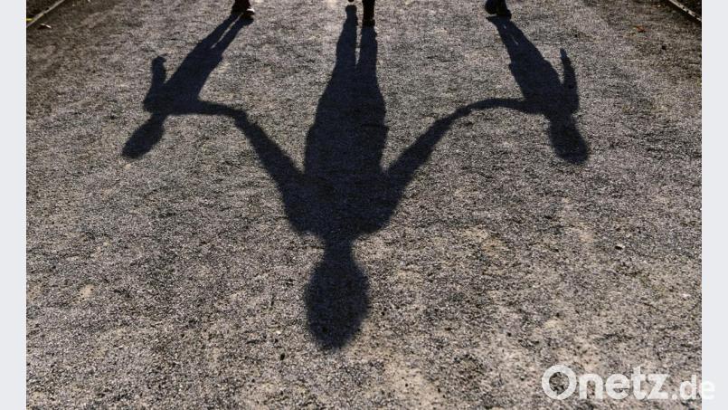 Der Schatten einer Frau mit ihren beiden Kindern auf einen Gehweg. Alleinerziehende in Bayern sollen künftig steuerlich entlastet werden Bild: Peter Kneffel/dpa