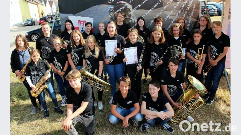 Freudestrahlend präsentieren die ausgezeichneten Jungbläserinnen ihre Urkunden im Kreis ihrer Orchesterkollegen zusammen mit der Dirigentin des Nachwuchsorchesters, Karin Raab (Zweite von rechts). Bild: bph