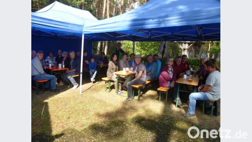 Die Besucher, unter ihnen BIV-Kreisvorsitzender Alois Habeck, Bürgermeister Herbert Rudolph und Neumitglied Monika Reichel aus Dießfurt, freuen sich unterm Pavillondach über den ausgiebigen Regenguss und genießen Kaffee, Kuchen sowie am Abend ein von zweitem Imkerchef Manfred Bergler gespendetes Fass Zoigl und Brotzeiten. Bild: bk