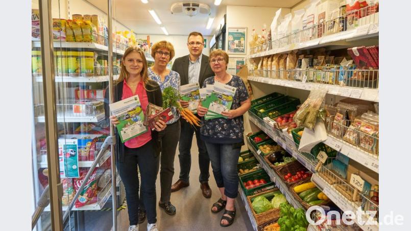 Mirjam Opitz (von links), Projektleiterin bei Fraunhofer SCS, die Verkäuferinnen Jutta Dötterl und Gisela Gmeiner (rechts) präsentieren mit Geschäftsführer Martin Schmid (Zweiter von rechts) den neuen Verkaufsflyer im mobilen Dorfladen. Bild: njn