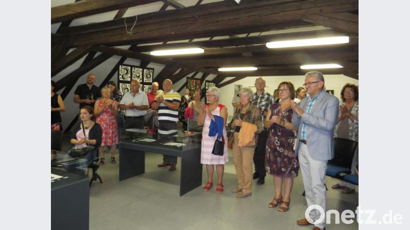 Zahlreiche Vernissagegäste applaudierten der Künstlerin und der Rockband Beifall. Bild: ubb