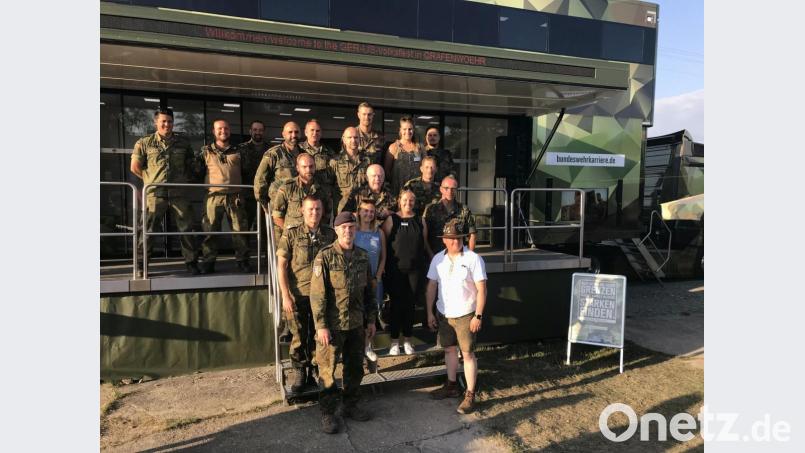 Am Karriere-Truck der Bundeswehr dankt Command Sergeant Major Michael Sutterfield (rechts in Lederhosen) den Organisatoren, Soldaten, Reservisten und Helfern. Hauptfeldwebel Andre Potzler (vorne, links) hatte die Waffen- und Geräteschau beim Volksfest organisiert. Bild: mor