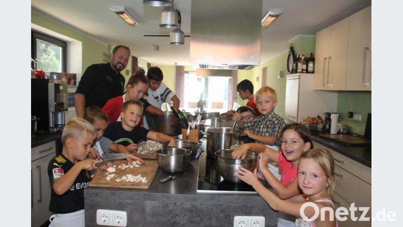 Mit Eifer waren die Kinder beim Zubereiten der Pizza dabei, das machte auch Spitzenkoch Andreas Meier (links) großen Spaß. Bild: frd