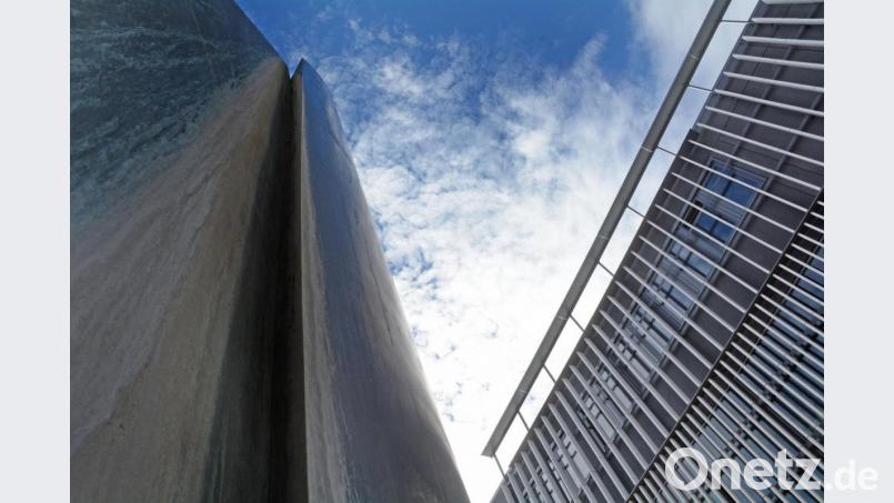 Gegenpole unter weiß-blauem Himmel in der Innenstadt: der hochaufragende Brunnen &quot;Entfaltung&quot; neben der NOC-Fassade. Bild: Gabi Schönberger