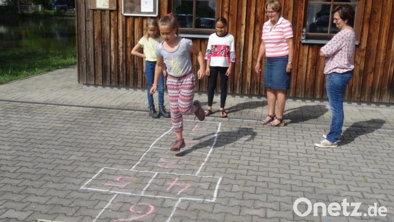 Himmel und Hölle: Als es noch keine Computer gab, waren solche Hüpfspiele sehr beliebt – heute kennen die Kinder sie nicht mehr. Beim Obst- und Gartenbauverein Hahnbach durften sie das Kästchen-Hüpfen ausprobieren und hatten viel Spaß dabei. Bild: hka