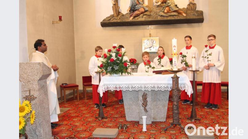 Mit Rosen sagen die Ministranten zum Beginn des von Pfarrer Julius Johnrose gefeierten Gottesdienst Dank. Bild: pi