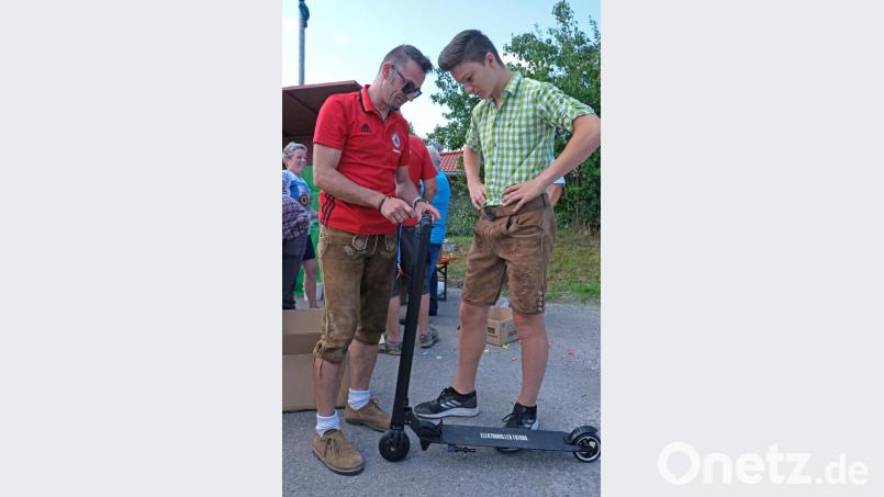 Ein paar kurze Erklärungen von Spartenleiter Sandro Lugert (links) und Max Grundler kann mit dem Hauptgewinn der TSV-Tombola, einem E-Scooter, losbrausen. Bild: nm