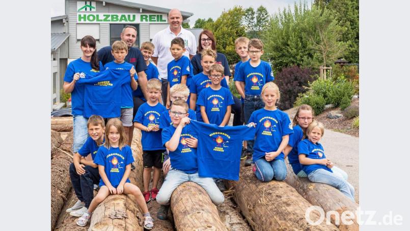Im Sägewerk der Firma Holzbau Reil erfahren die Jungen und Mädchen der Kinderfeuerwehr nicht nur einiges über den Betrieb. Firmen-Chef Christian Reil (hinten, Zweiter von rechts) stattet sie mit neuen T-Shirts mit der Aufschrift „Hirschauer Feuerfunken“ aus. Mit den Kindern bedanken sich dafür die Betreuerinnen Marina Schlaffer (hinten rechts) und Claudia Jasinsky (hinten links) sowie Kommandant Sebastian Jasinsky (hinten, Zweiter von links). Bild: u