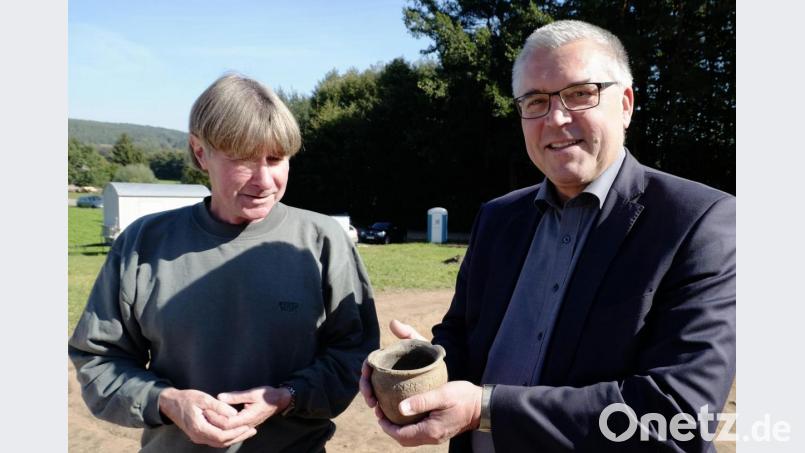 Behutsam hält Bürgermeister Richard Tischler eine Tonschale in Händen. Das Gefäß ist slawischer Herkunft. und wurde neben dem Grabhügel deponiert, erklärte Hans Losert (links). Bild: ohr
