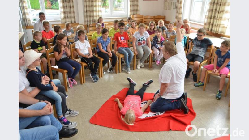 Der Helfer vor Ort Josef Solfrank erklärt den Kindern genau, wie mit bewusstlosen Personen verfahren wird. Bild: dob