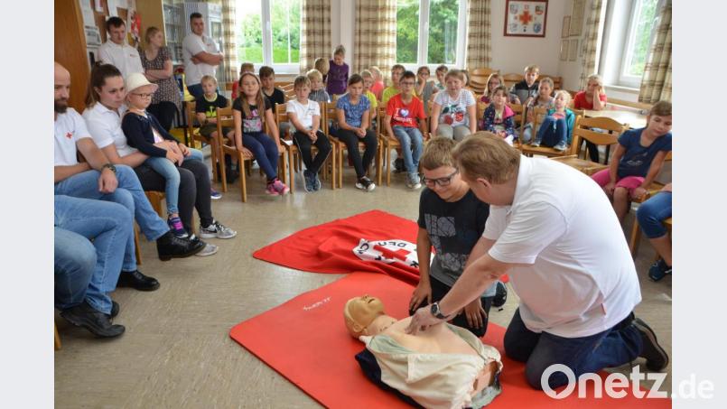 Der Helfer vor Ort Josef Solfrank erklärt den Kindern genau, wie mit bewusstlosen Personen verfahren wird. Bild: dob