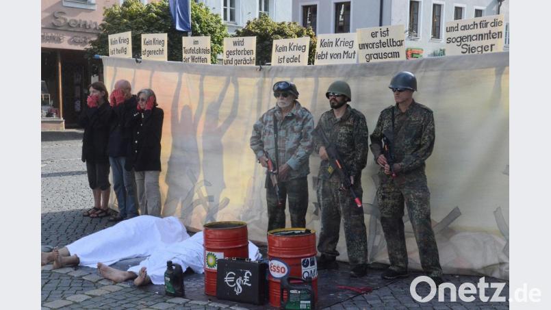 Die Menschen bleiben stumm, sehen, hören weg. Derweil kämpfen Soldaten um die Ölvorkommen. Zurückbleiben Leichen. Im Hintergrund prangern Friedensaktivisten mit Textzeilen aus dem Pur-Song &quot;Kein Krieg&quot; den Rüstungswahnsinn an. Bild: Kunz