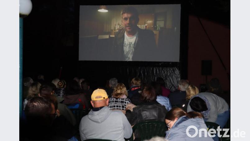 Trotz des unbeständigen Wetters kommen etliche Besucher zum Freiluftkino in den Park der Stützelvilla. Bild: wrm