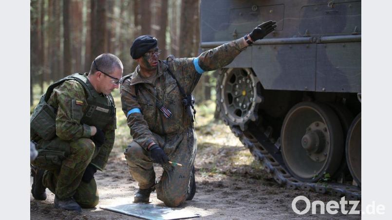 Zwei Kommandierende bei einer improvisierten Lagebesprechung am Rande eines Manövers in Litauen: Oberstleutnant Peer Papenbroock (mit geschwärztem Gesicht) weist bei der Abschlussübung den litauischen Brigadekommandeur ein. Bild: Bundeswehr