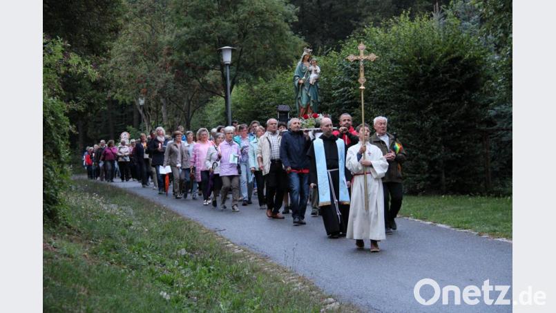 Gut 100 Marienverehrer ziehen am Feiertag Mariä Himmelfahrt bei einbrechender Dunkelheit betend und singend mit einer blumengeschmückten Statue der Gottesmutter von der Bildkapelle in die Wallfahrtskirche St. Felix. Bild: prh