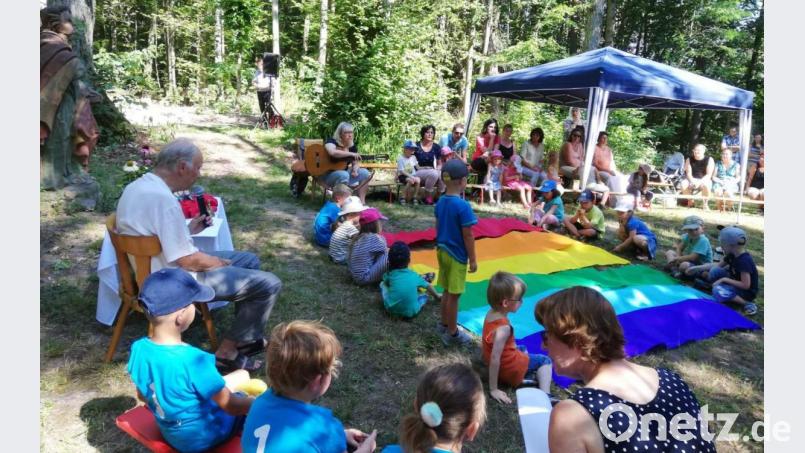 Durch die von Stadtpfarrer Hans-Peter Bergmann (links) geleitete Abschlussandacht des St.-Wolfgang-Kindergartens an der Kreuzigungsgruppe am Kalvarienberg zieht sich das Thema „Das Leben ist bunt wie ein Regenbogen“ wie ein roter Faden. Zu jeder von den Elternbeiräten vorgetragenen Fürbitte rollen die Kinder ein Tuch mit einer der Regenbogenfarben aus. Bild: u