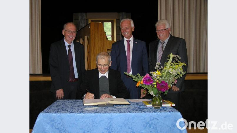 Pfarrer Hans Riedl (sitzend) durfte sich im Beisein von zweitem Bürgermeister Dr Günther Fütterer (stehend von links) Gemeindeoberhaupt Peter König und drittem Bürgermeister Richard Stock ins Goldene Buch der Gemeinde Neusorg eintragen. Bild: öt