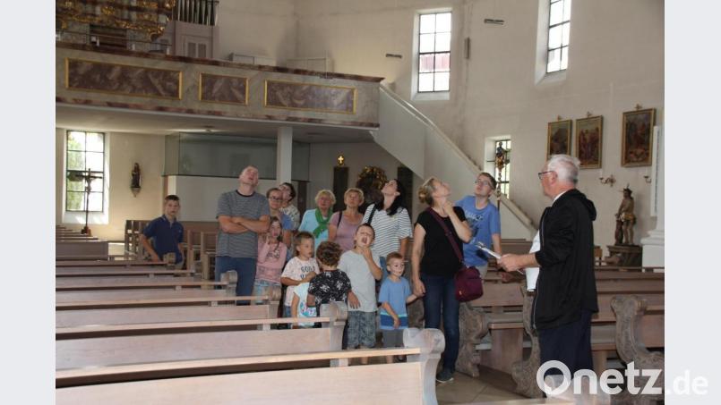 Kirchenpfleger Günther Flierl (rechts) erklärte den Besuchern die Kirchenmalereien und führte sie auch auf den Kirchturm. Bild: frd