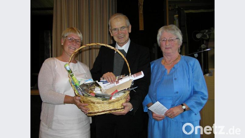 Jutta Panzer (links) und Vertrauensfrau Anneliese Bachmann (rechts) von der evangelischen Kirchengemeinde übergaben an Pfarrer Hans Riedl einen Korb. Bild: öt