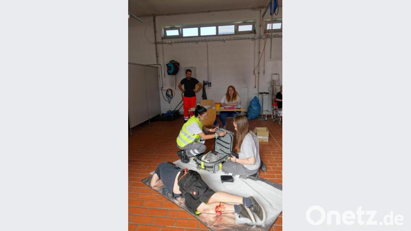 Katharina Regn (vorne links) und Laura Flügel (vorne rechts) versorgen bei ihrer praktischen Prüfung bei Lehrgangsleiter Daniel Schenkl (hinten links) und Ausbilderin Melissa Pregler (hinten rechts) einen bewusstlosen Patienten. Bild: Bayerisches Rotes Kreuz/exb