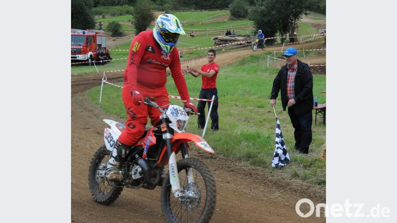 Nach drei Stunden signalisierte Bürgermeister Winfried Franz (rechts) für „Zündapps letzte Rache“ aus Paderborn, dass sie das Mofa-Rennen in Neukirchen gewonnen haben. Bild: gfr