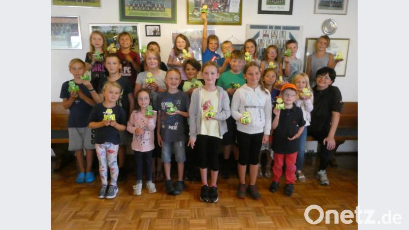Mit großem Stolz präsentierten die 23 Buben und Mädchen zusammen mit der Jugendbeauftragten Barbara Neugirg (vorne rechts) ihre fertigen Tontopf-Frösche. Bild: ang