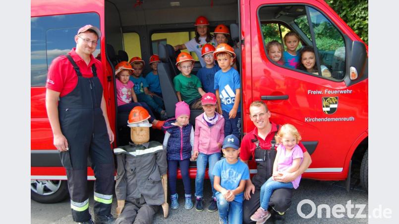 Kommandant Robert Maier (kniend vorne rechts) und Feuerwehrkamerad Florian Hart kümmern sich um die Buben und Mädchen beim Ferienprogramm der Feuerwehr. Bild: sm