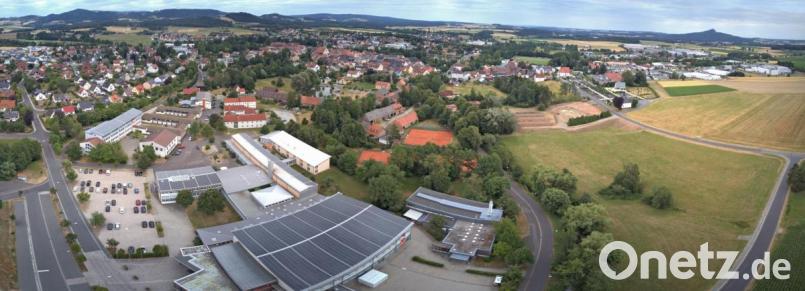 Statt sie zu sanieren, lässt der Landkreis Tirschenreuth die Kemnather Realschule (links) ein paar Meter weiter neu bauen. Dafür vorgesehen ist die Wiese zwischen Berndorfer und Badstraße (rechts). Im Vordergrund ist die Mehrzweckhalle zu sehen. Bild: dtr