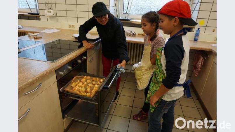 Jeremias und seine Schwester überprüfen mit Veranstalterin Roswitha Reil, die gebackenen Blätterteig-Häppchen. Bild: Hopperdietzel, Dominik