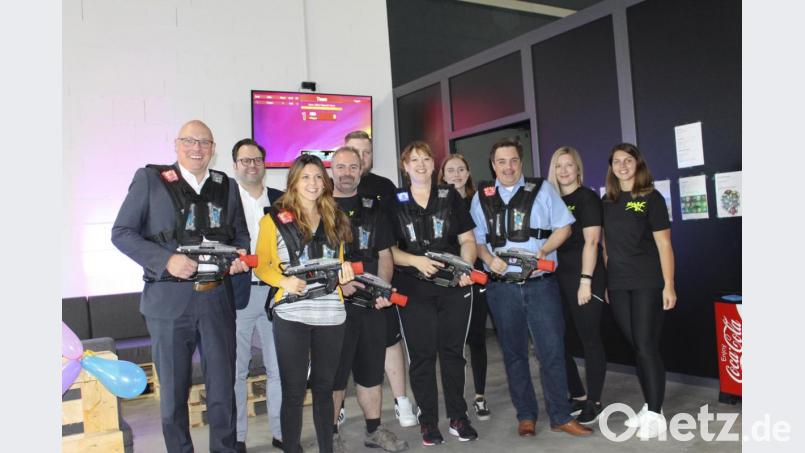 Oberbürgermeister Oliver Weigel (links), Stefanie Fürst von der Wirtschaftsförderung der Stadt (Dritte von links) und Sebastian Macht (Dritter von rechts) gratulierten zur Eröffnung und griffen zur Laserpistole. Mit im Bild das Ehepaar Sandra und Matthias Lutz (Mitte) und das Team der Action-Halle. Bild: fphs