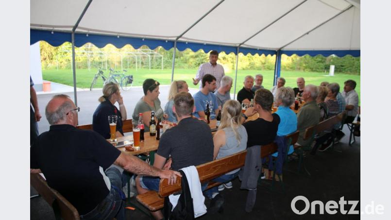Bei der CSU-Sommerradtour berichtet Bürgermeister Edgar Knobloch (stehend) über die Dorfsanierung in Hütten und nimmt sich den Fragen der Bürger an. Bild: sne