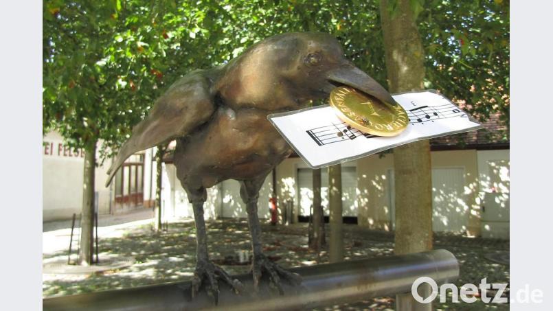 Der Rabe im Schlosshof hält einen Notenschnipsel im Schnabel. Bild: sck