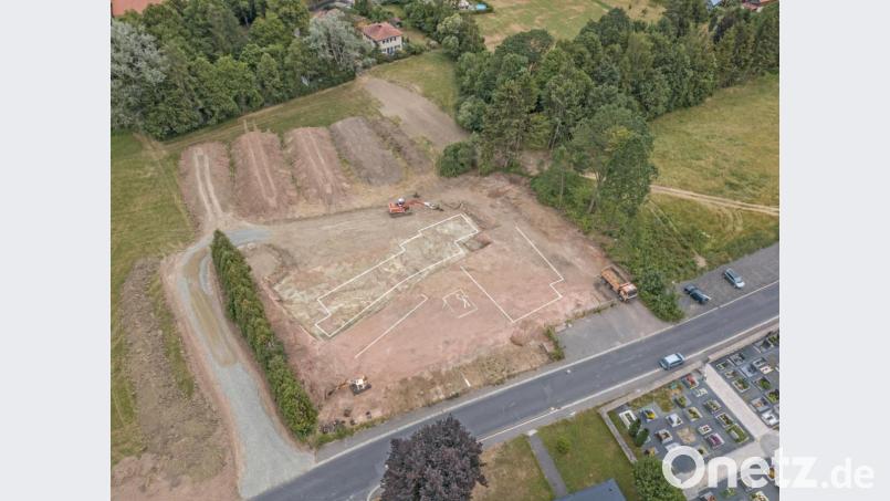 Feinsäuberlich hat der Bagger den Aushub in mehrere, rund 500 Kubikmeter große Aufschüttungen (oben) für die Beprobung des Erdmaterials getrennt. Die Linien markieren in etwa die Lage der Fundamente des neuen Kinderhauses an der Berndorfer Straße (unten). Bild: dtr