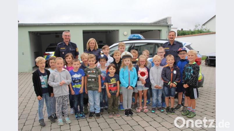 Die Kinder ließen sich gerne mit ihren „Kollegen“ (hinten von links) Polizeihauptkommissar Georg Pfannenstein, Polizeihauptmeisterin Daniela Ziereis und Polizeihauptkommissar Karl-Heinz Senft für ein Erinnerungsfoto ablichten, schließlich wollen ja einige von ihnen nach dem Besuch Polizist werden. Bild: frd