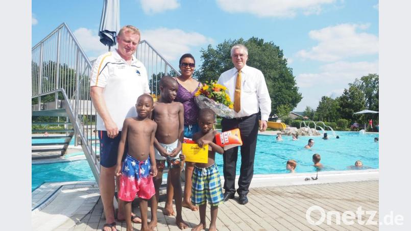 Betty Ikedo ist heuer die 100.000 Besucherin im Perschener Freibad. Bürgermeister Richard Tischler und Bademeister Norbert Wurmstein (links) gratulierten ihr und den drei Söhnen Noel, Ezekiel und Peter mit einem Blumenstrauß und einer Familienkarte für die nächste Freibad-Saison. Bild: bl