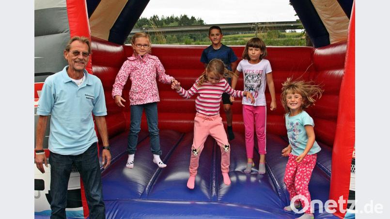 Die Kinder haben ihren Spaß am Familiennachmittag auf und vor der Hüpfburg. Siedlerchef Heribert Schiller (links) freut sich über die gute Stimmung. Bild: zer
