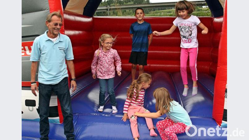 Die Kinder haben ihren Spaß am Familiennachmittag auf und vor der Hüpfburg. Siedlerchef Heribert Schiller (links) freut sich über die gute Stimmung. Bild: zer