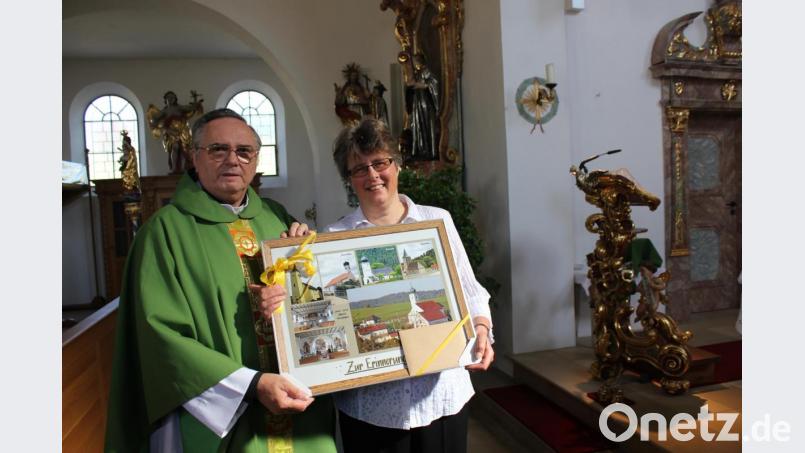 Pfarrgemeindesprecherin Gudrun Fischer Utzenhofen übereicht an Pfarrer Josef Kanovsky eine Collage auf dem der Pfarrhof die Pfarrkirche von Utzenhofen und alle Filialkirchen abgebildet sind. Bild: aun