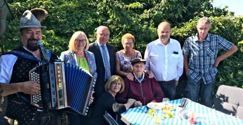 Josef Lindner (sitzend) feiert im Garten von Schwiegertochter Johanna Lindner den 100. Geburtstag. Es gratuliert nicht nur die weitere Familie mit Tochter Evi Driessen (kniend) und Freia Bachmayer (Dritte von rechts), sondern auch jede Menge örtliche Prominenz. Bild: mef