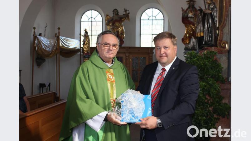 Bürgermeister Stefan Braun (Markt Kastl) übereicht an Pfarrer Josef Kanovsky den Ehrenteller des Marktes Kastl. Bild: aun