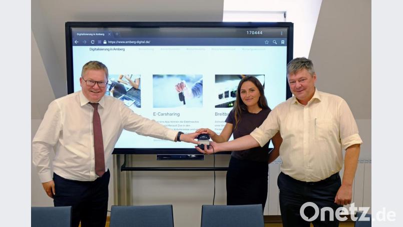 Oberbürgermeister Michael Cerny (von links), Altstadt-Wirtschaftsförderin Verena Fitzgerald und Gewerbebau-Geschäftsführer Karlheinz Brandelik geben die neue Webseite www.amberg-digital.de frei. Bild: Stadt Amberg, Susanne Schwab/exb