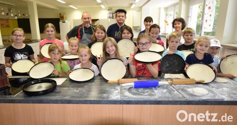 Mit der Hilfe von (hinten, von links) Pizzabäcker Dennis Stark, Reinhard Götz, Edeltraud Pickel und Edeltraud Koller gelingt den Kindern die erste selbst gemachte Pizza. Bild: no