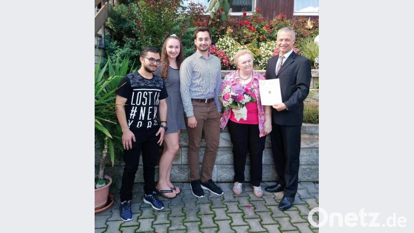 Zweiter Bürgermeister Thorsten Grädler (rechts) und drei Enkelkinder gratulieren der Jubilarin Frieda Paulus zum 80. Geburtstag. Bild: Stefanie Gradl