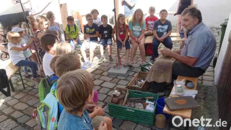 Archäologe Lothar Breinl zeigt den Kindern im Stadtmuseum Werkzeuge und Geräte aus der Steinzeit. Bild: hka