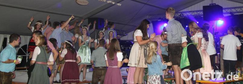 Auf dem erhöhten Platz im Zelt heizten die Kirwamoidln in ihren feschen Dirndln und die schneidigen Kirwaburschn in ihrer „Ledernen“ zusammen mit der Band die Stimmung an und rissen das Publikum mit. Bild: ohr