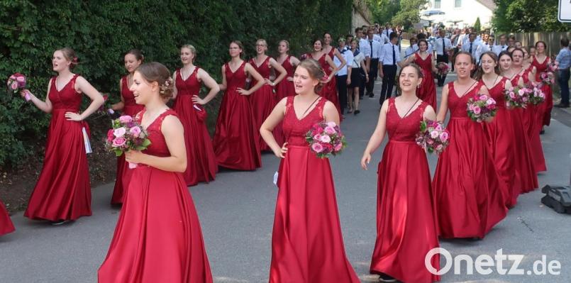 Die Festdamen des Burschenvereins Neukirchen mit Mädchengruppe marschierten in eleganten roten Kleidern voran, dahinter folgte die Burschengruppe. Bild: Hirsch