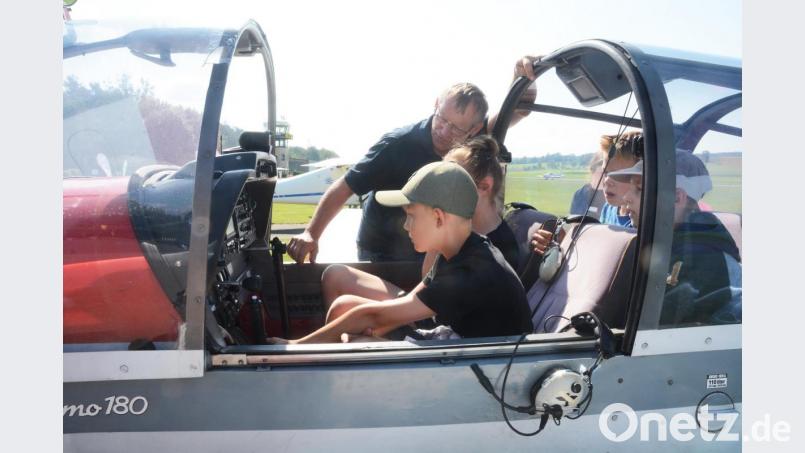 Pilot Josef Eger erklärt den wissbegierigen Kindern die Steuerelemente. Bild: Gabi Schönberger