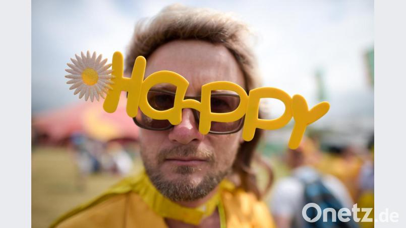 Ein Besucher eines Festivals in Großbritannien mit einer „Happy“-Brille. Foto: Ben Birchall/PA Wire Bild: Ben Birchall