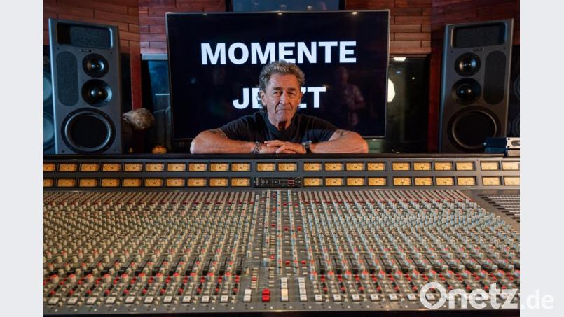 Peter Maffay lächelt, hinter dem Mischpult stehend und vor einer Wand, auf der "Momente Jetzt" zu sehen ist. Foto: Peter Kneffel/Archiv Bild: Peter Kneffel